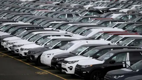 Reuters Hundreds of new Land Rovers, some with plastic covers, are seen on a parking lot at a factory in Halewood.