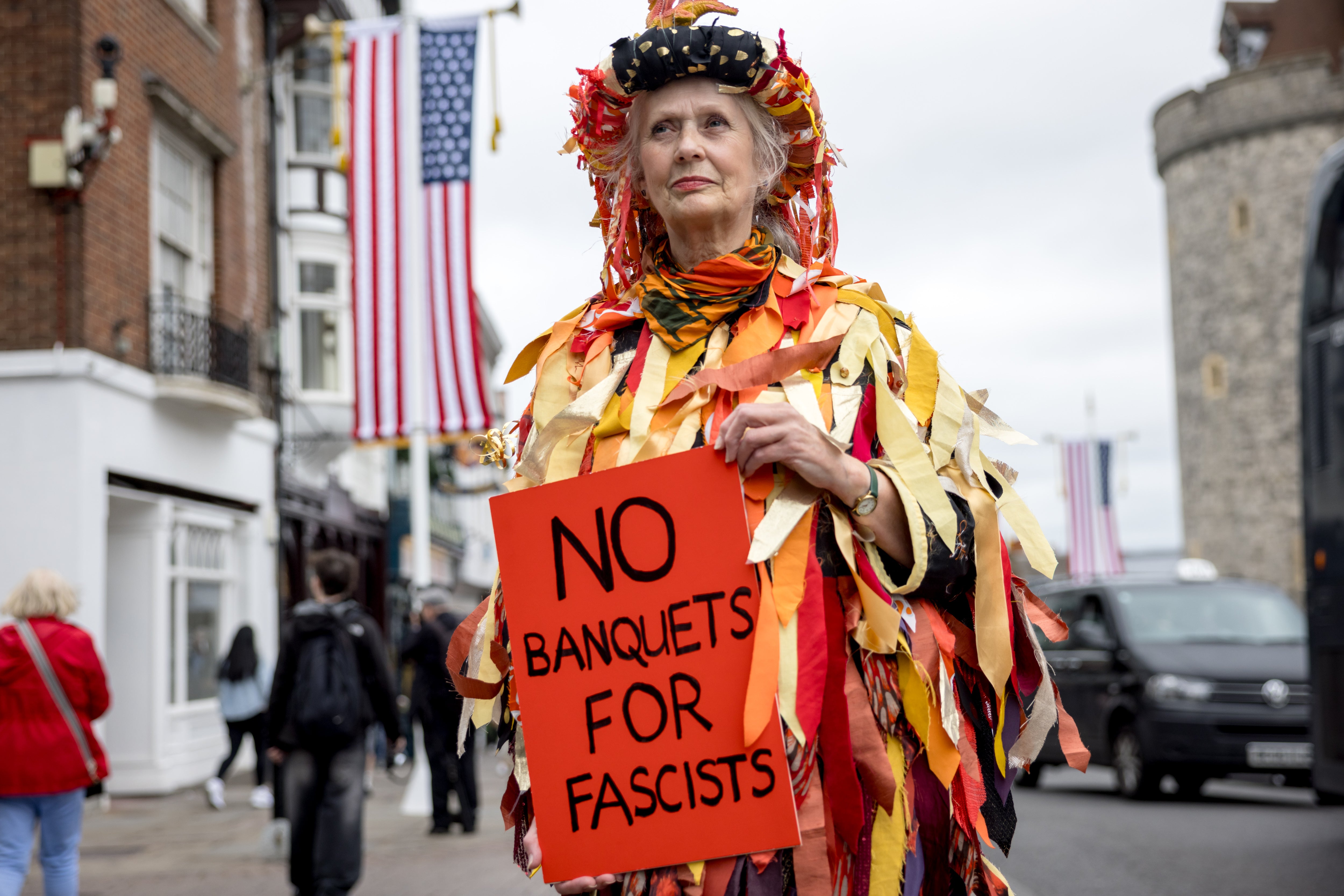 Protesters in Windsor, below a US flag, held anti-Trump placards